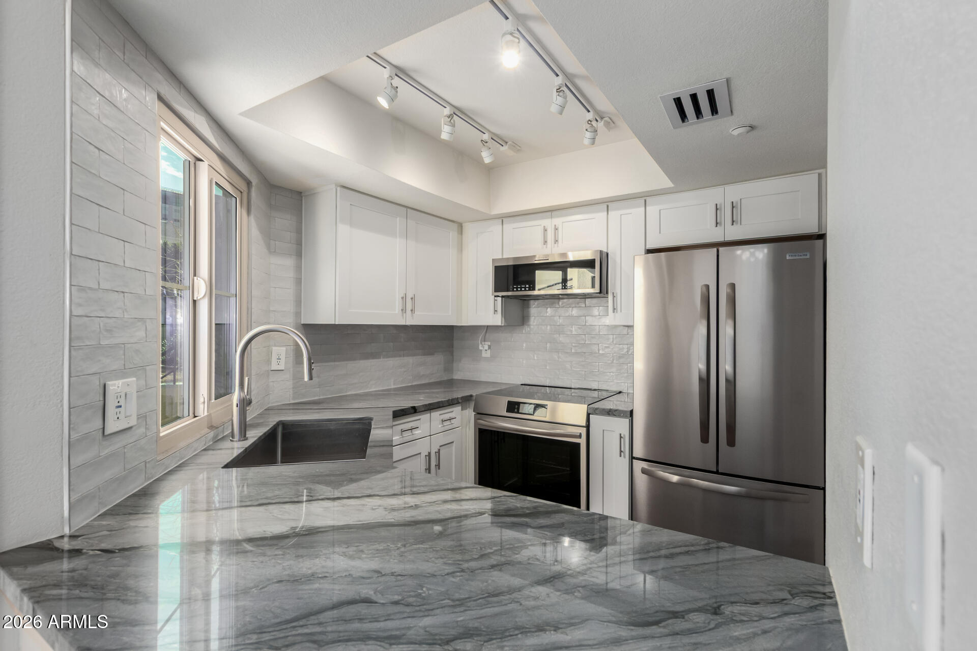 100 East Fillmore Street, Unit 119 Phoenix, AZ 85004 - Photo 13 of 34 a kitchen with stainless steel appliances granite countertop a refrigerator sink and stove