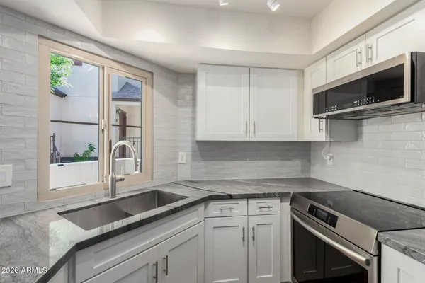 a view of a kitchen with a sink and large window