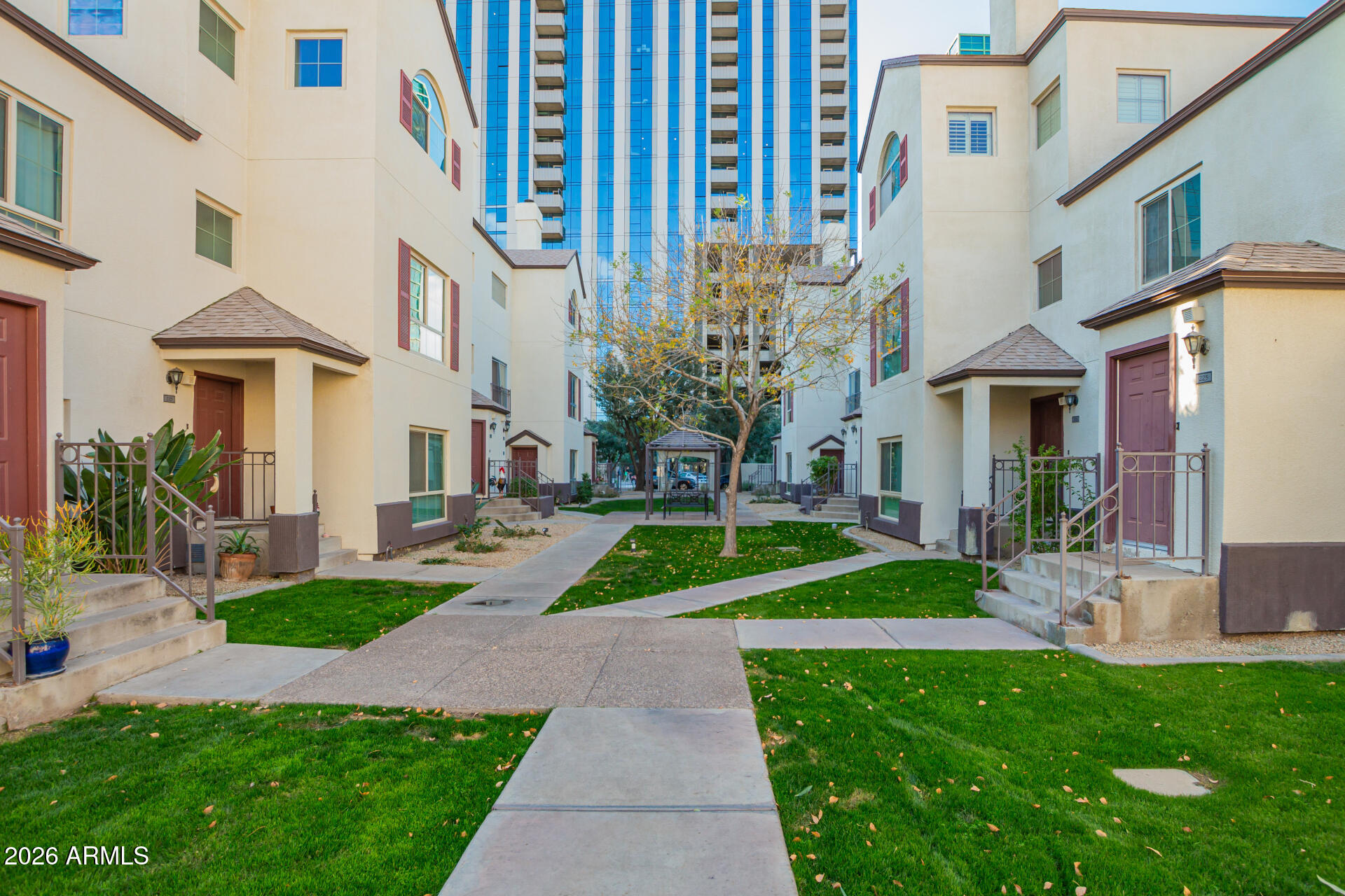 100 East Fillmore Street, Unit 119 Phoenix, AZ 85004 - Photo 32 of 34 a view of a white house with a yard table and chairs