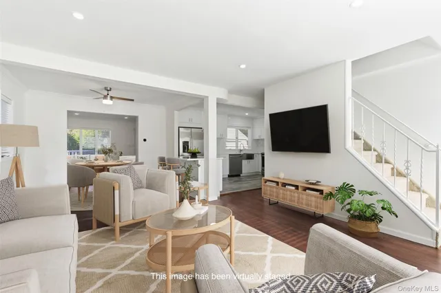 a living room with furniture a flat screen tv and a potted plant