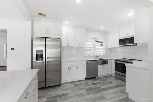 a kitchen with cabinets stainless steel appliances and sink