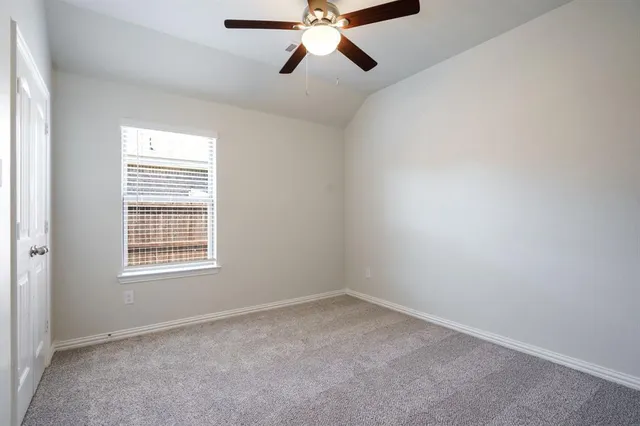 an empty room with a window and a ceiling fan
