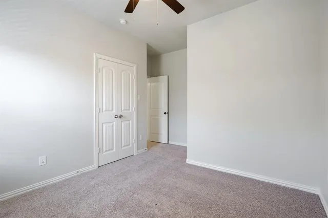an empty room with closet and windows