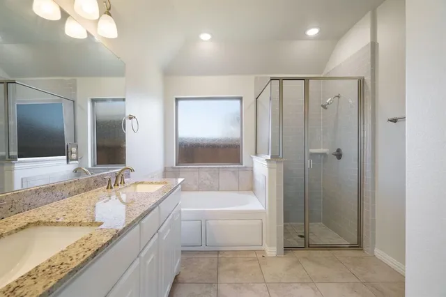 a spacious bathroom with a granite countertop sink mirror and shower