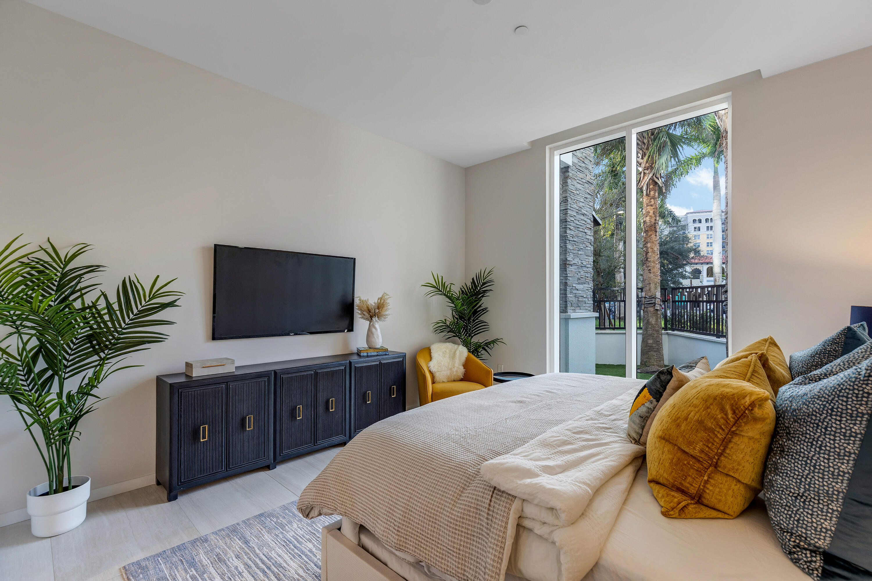 200 Southeast Mizner Boulevard, Unit 106 Boca Raton, FL 33432 - Photo 12 of 43 a bedroom with a large bed and a flat screen television