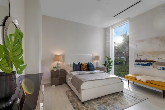 a bedroom with a bed table and a potted plant
