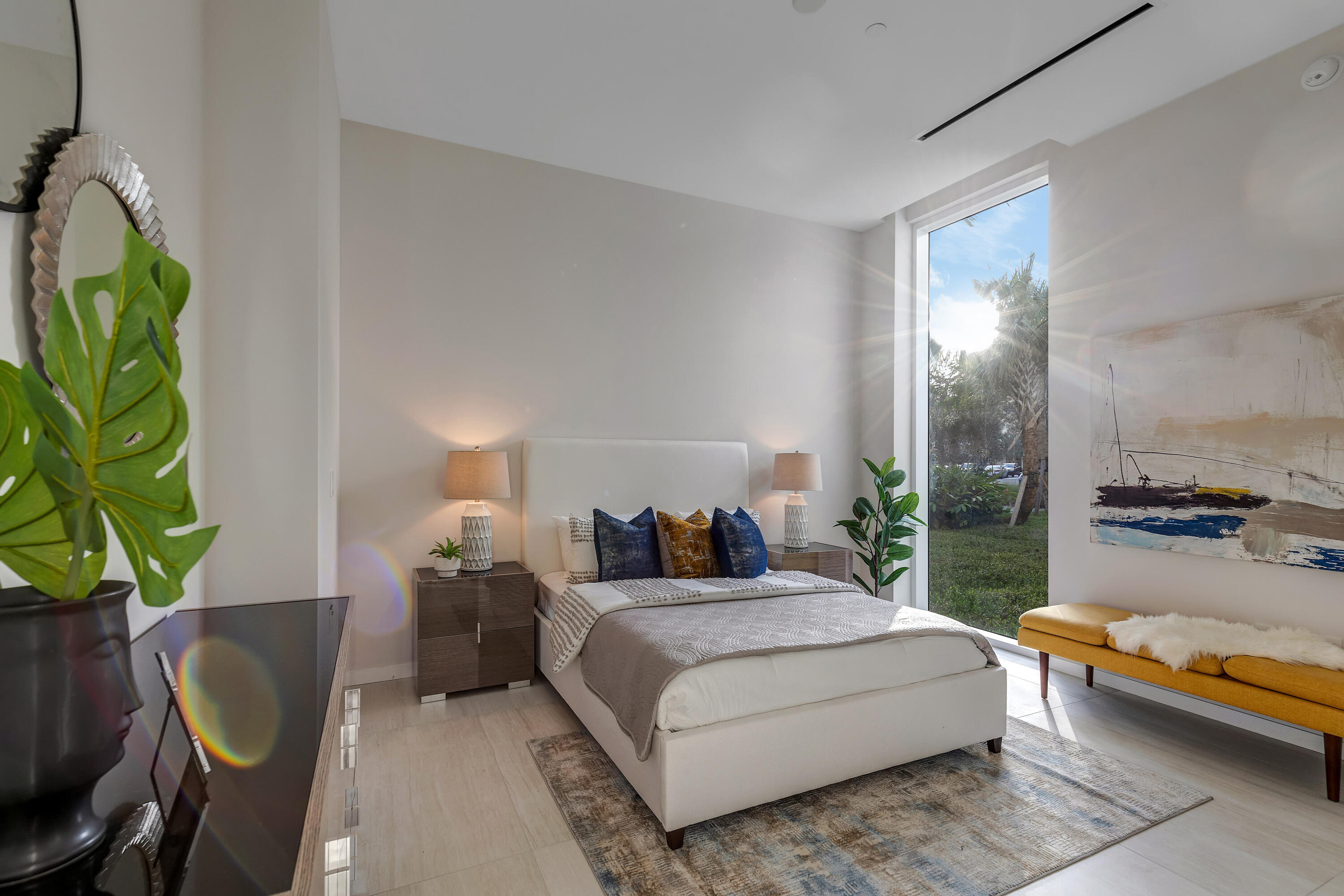 200 Southeast Mizner Boulevard, Unit 106 Boca Raton, FL 33432 - Photo 14 of 43 a bedroom with a bed table and a potted plant