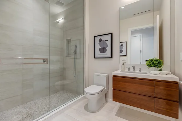 a bathroom with a sink a toilet and shower