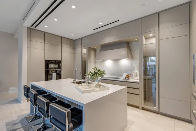 a kitchen with a sink a kitchen island and stainless steel appliances