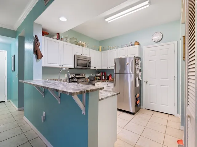 a kitchen with stainless steel appliances granite countertop a refrigerator a stove a sink and a refrigerator