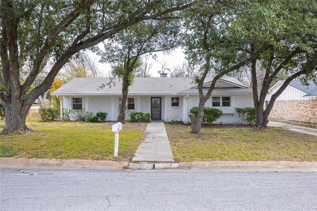 a front view of a house with a garden and tree