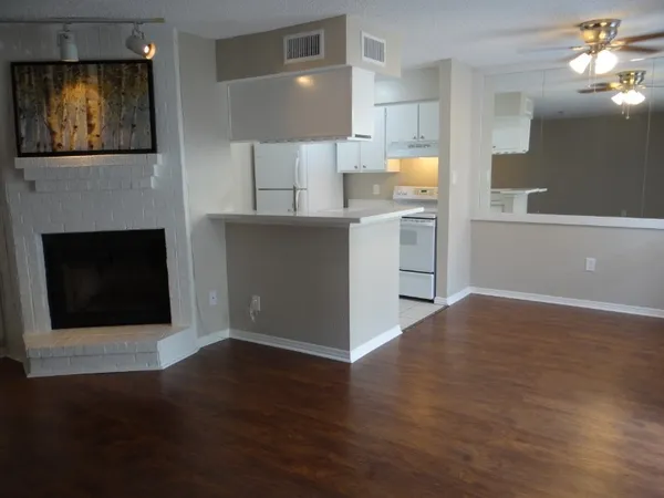 a view of a kitchen with wooden floor and a fireplace