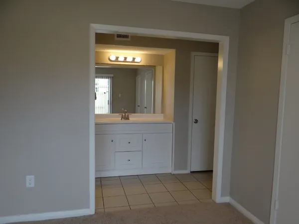 a spacious bathroom with a mirror sink and vanity