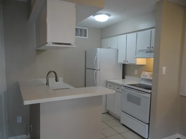 a kitchen with a sink a refrigerator and cabinets