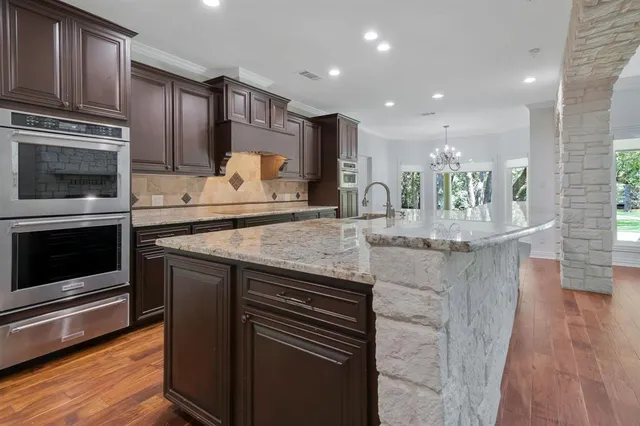 a kitchen with kitchen island granite countertop wooden cabinets and a stove