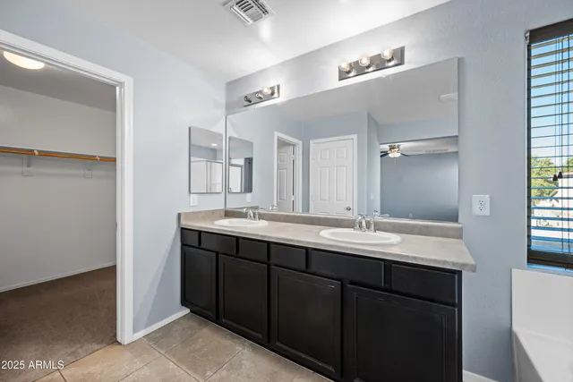 a bathroom with a granite countertop sink double vanity and a mirror