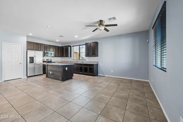 a kitchen with stainless steel appliances granite countertop a stove top oven a sink and a refrigerator