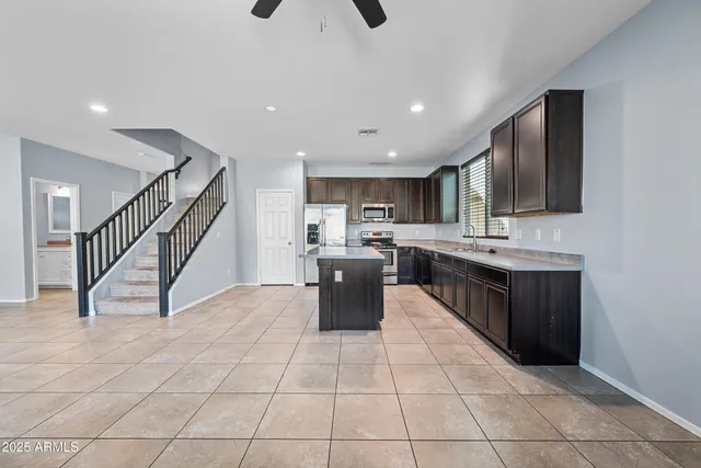 a kitchen with stainless steel appliances kitchen island granite countertop a sink and cabinets