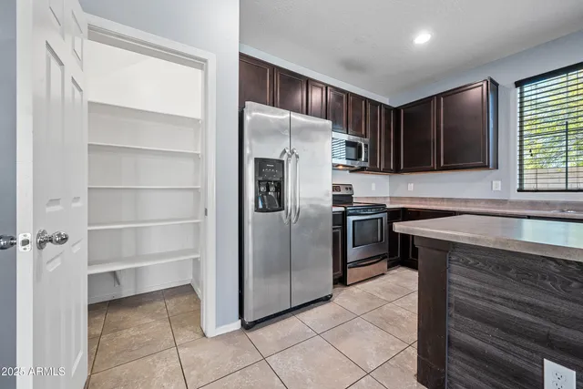a kitchen with granite countertop a refrigerator and a sink