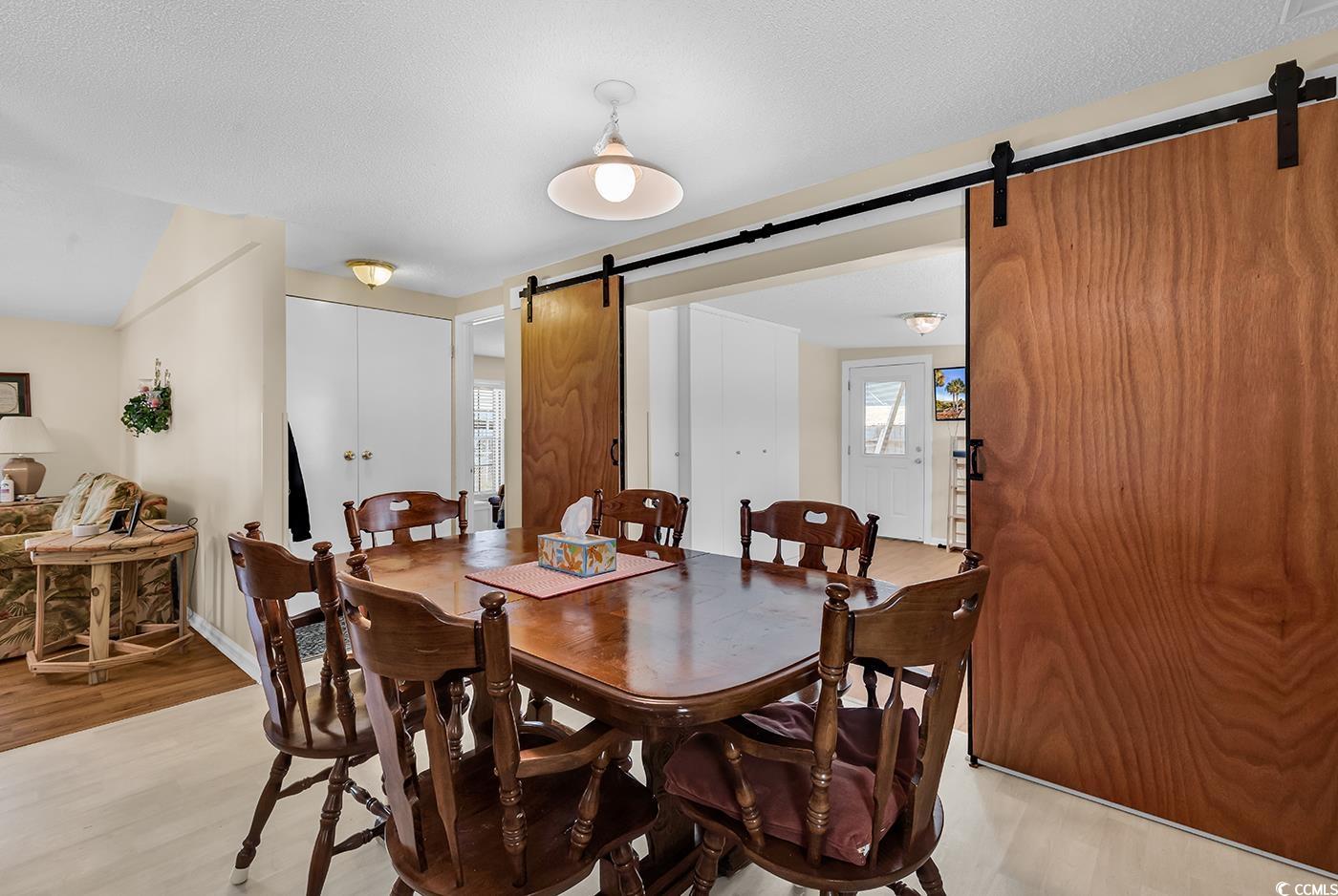 449 Rainbow Drive Murrells Inlet, SC 29576 - Photo 13 of 33 Dining space featuring a barn door and light wood-type flooring