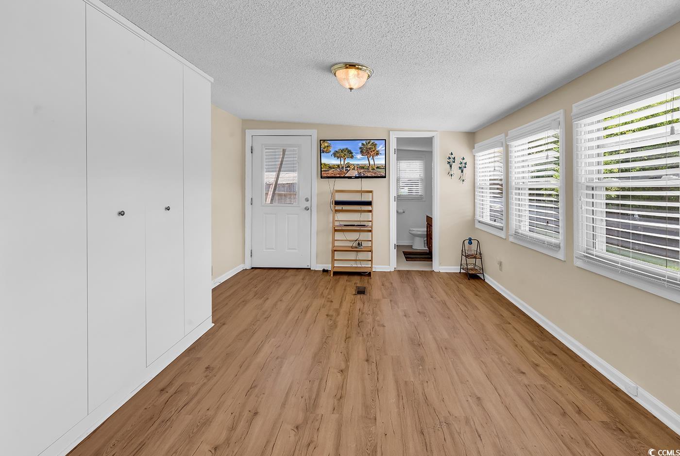 449 Rainbow Drive Murrells Inlet, SC 29576 - Photo 14 of 33 Unfurnished living room with light wood-style floors and a textured ceiling