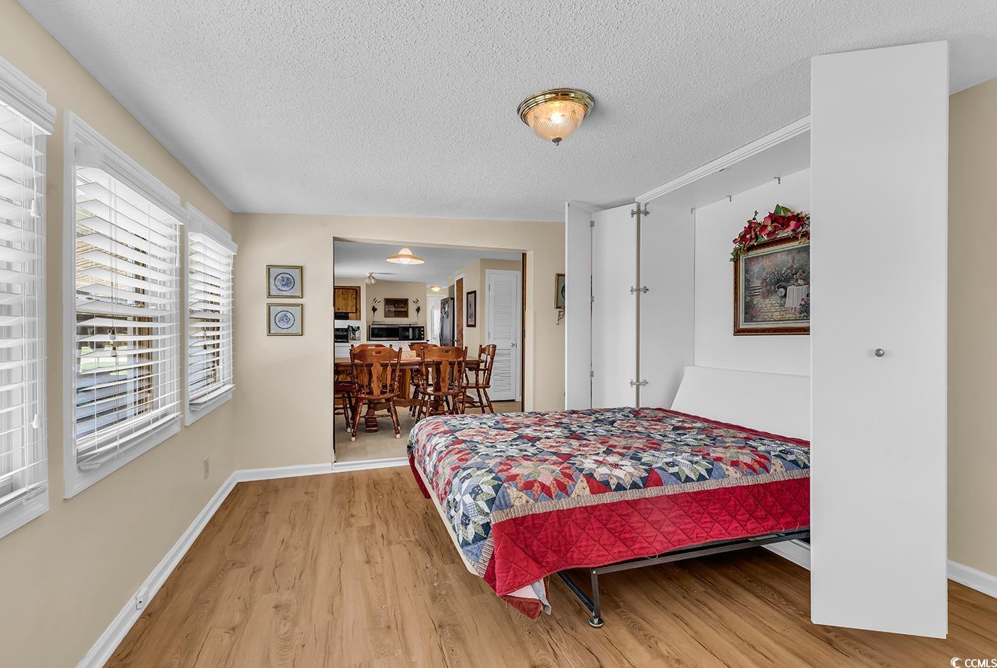 449 Rainbow Drive Murrells Inlet, SC 29576 - Photo 17 of 33 Bedroom with wood finished floors and a textured ceiling