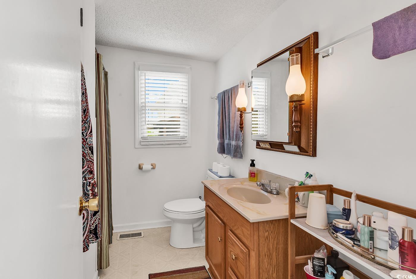 449 Rainbow Drive Murrells Inlet, SC 29576 - Photo 18 of 33 Bathroom featuring vanity, a textured ceiling, tile patterned floors, and a shower