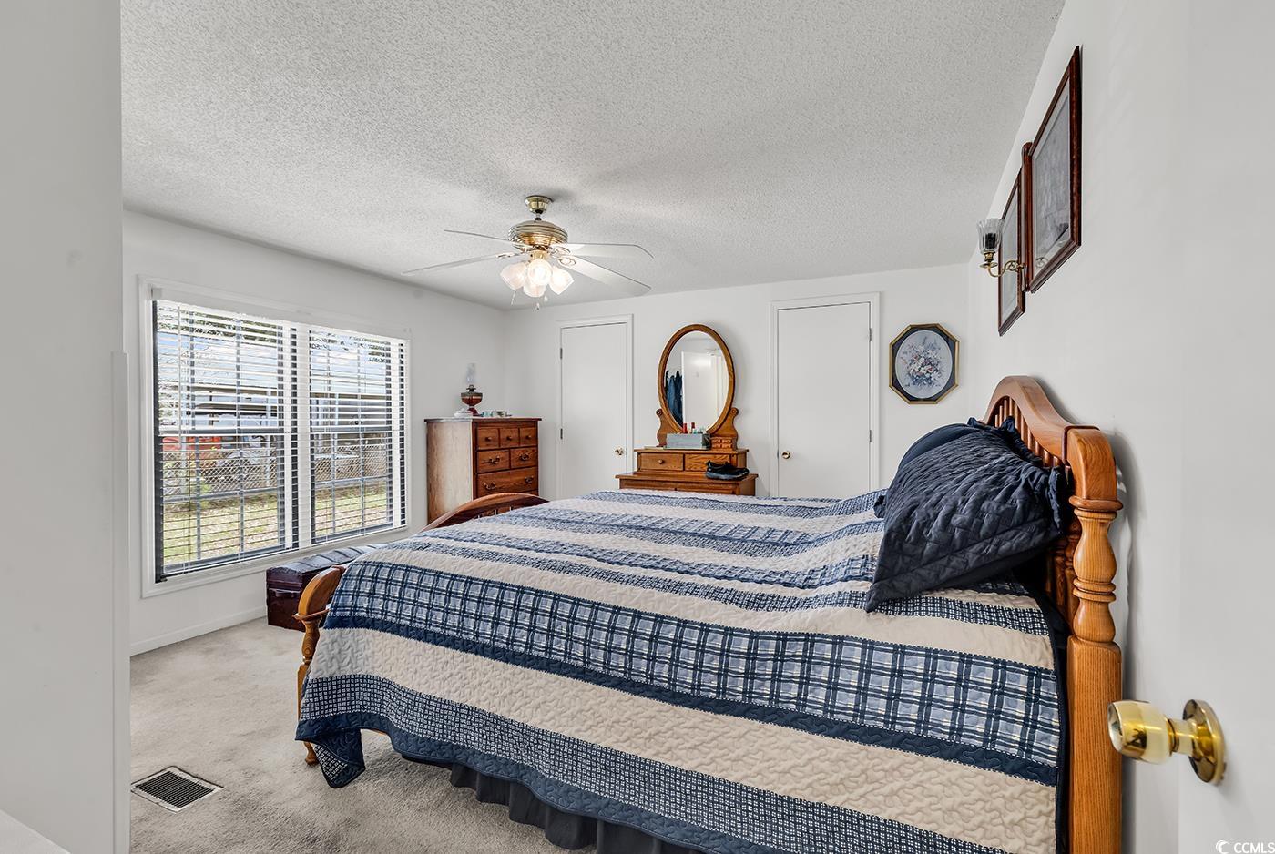 449 Rainbow Drive Murrells Inlet, SC 29576 - Photo 19 of 33 Carpeted bedroom with a textured ceiling and ceiling fan