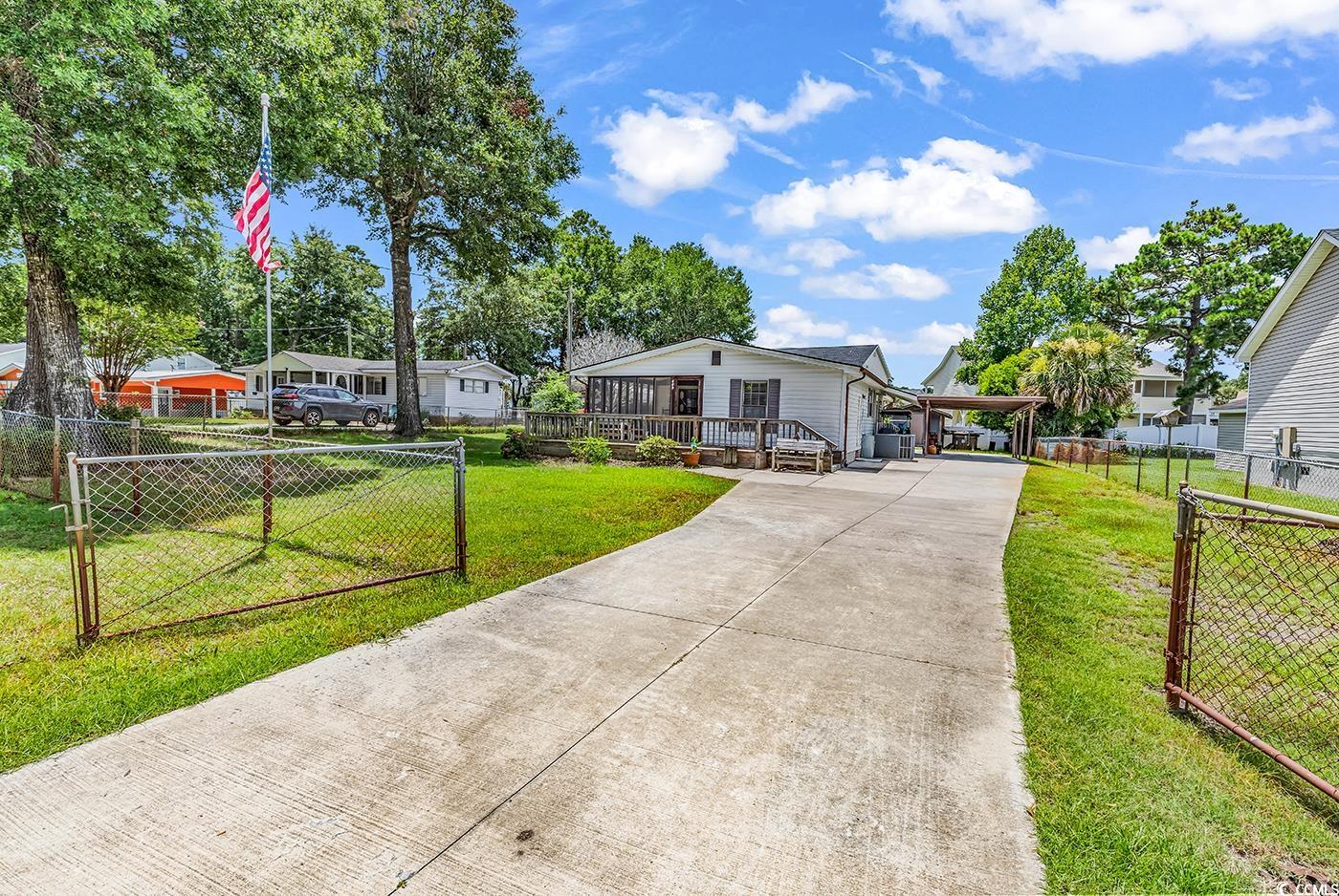 449 Rainbow Drive Murrells Inlet, SC 29576 - Photo 28 of 33 View of front facade featuring concrete driveway, a wooden deck, and an attached carport
