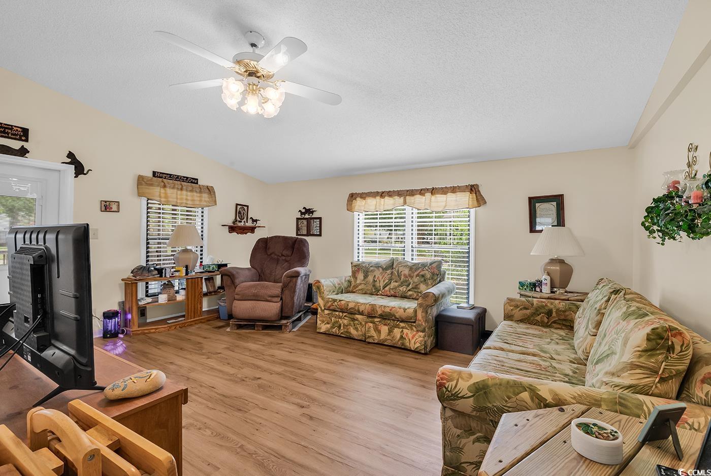 449 Rainbow Drive Murrells Inlet, SC 29576 - Photo 4 of 33 Living room featuring lofted ceiling, light wood finished floors, healthy amount of natural light, a textured ceiling, and ceiling fan