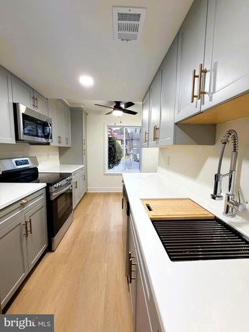 a large kitchen with stainless steel appliances granite countertop a stove a sink and a microwave