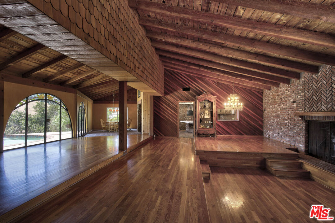 24962 Eldorado Meadow Road Hidden Hills, CA 91302 - Photo 17 of 19 a view of an empty room with wooden floor and a fireplace