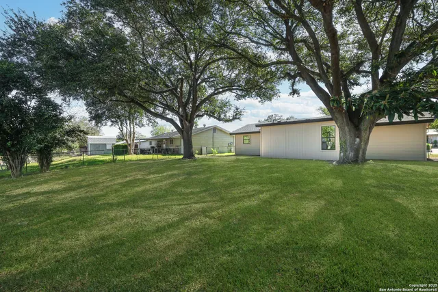 a front view of house with a garden and trees