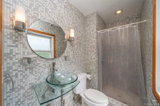 a bathroom with a toilet and a mirror