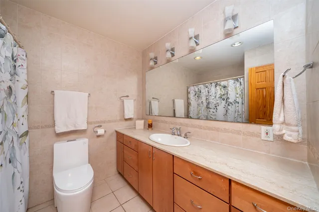 a bathroom with a granite countertop toilet sink and mirror