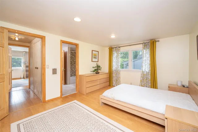 a bedroom with a large bed and wooden floor