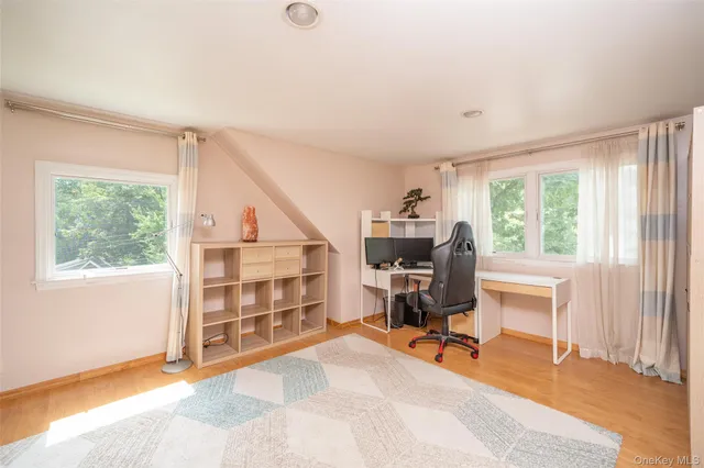 a view of a workspace with furniture and a window