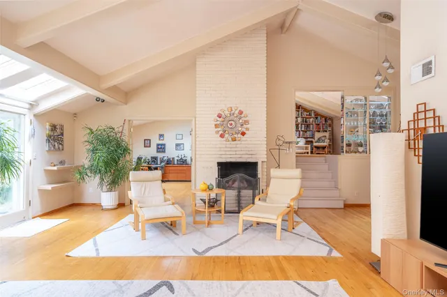 a living room with furniture a fireplace and a table with wooden floor