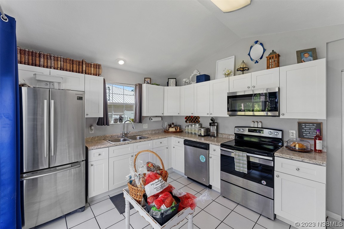 2617 35th Street Edgewater, FL 32141 - Photo 14 of 43 a kitchen with stainless steel appliances granite countertop a refrigerator sink and stove