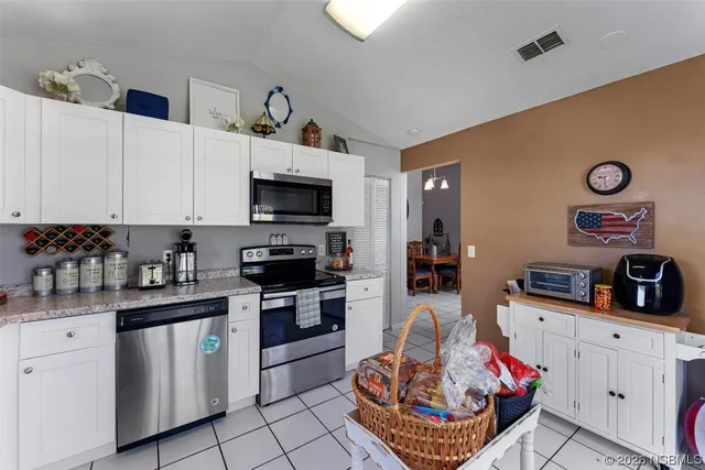 a kitchen with granite countertop a sink dishwasher stove and white cabinets