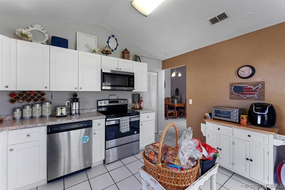 2617 35th Street Edgewater, FL 32141 - Photo 15 of 43 a kitchen with granite countertop a sink dishwasher stove and white cabinets