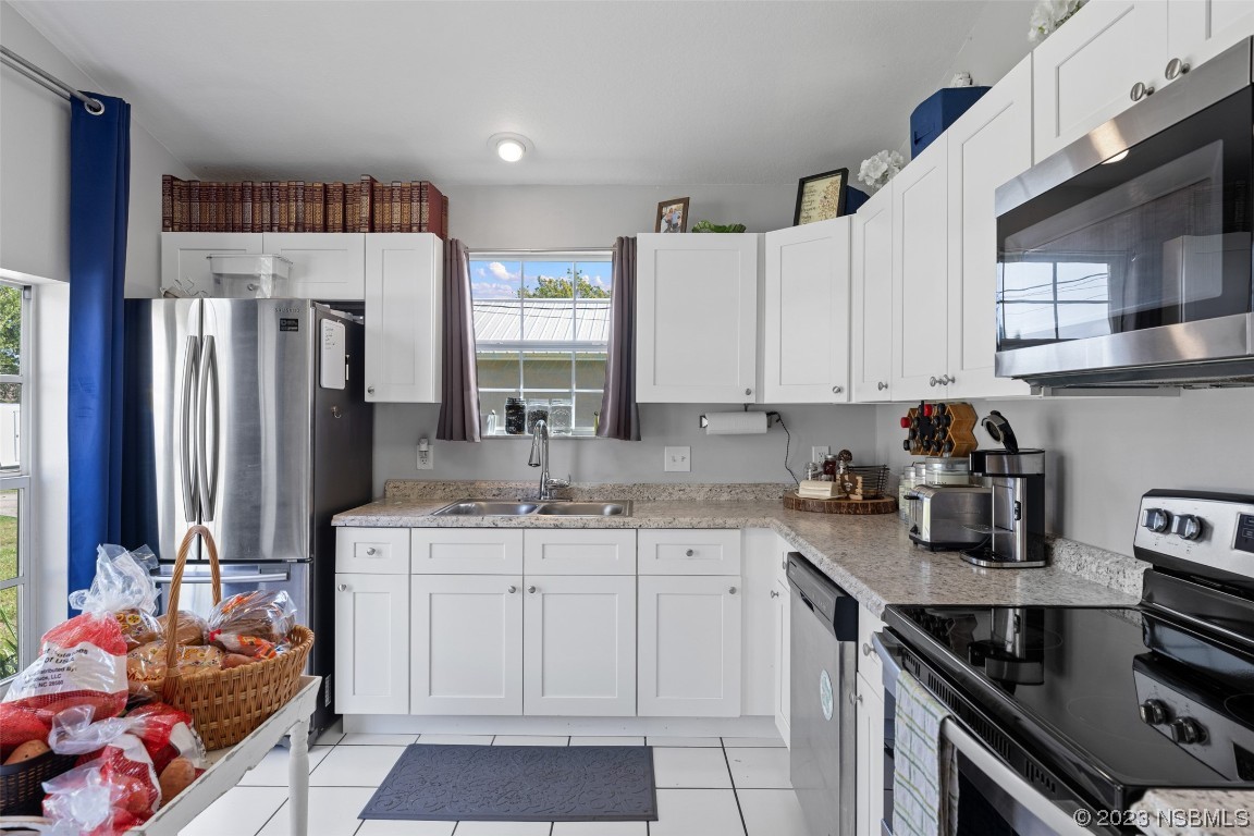 2617 35th Street Edgewater, FL 32141 - Photo 17 of 43 a kitchen with stainless steel appliances granite countertop a sink stove and refrigerator