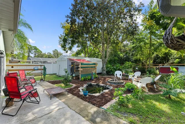 a view of backyard with outdoor seating and plants