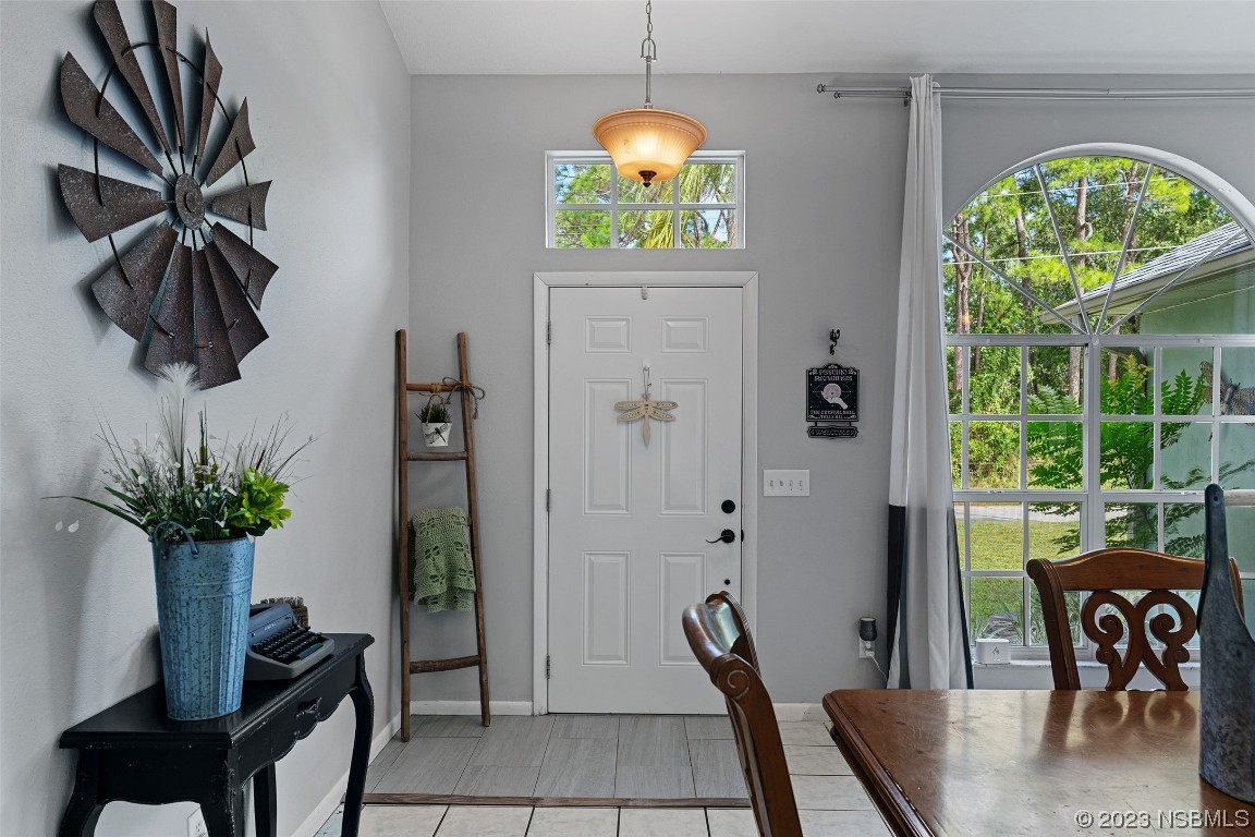 2617 35th Street Edgewater, FL 32141 - Photo 3 of 43 a dining room with furniture potted plants and a chandelier