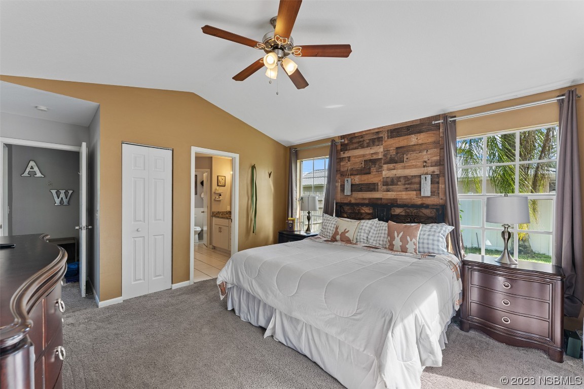 2617 35th Street Edgewater, FL 32141 - Photo 36 of 43 a bedroom with a large bed and a chandelier