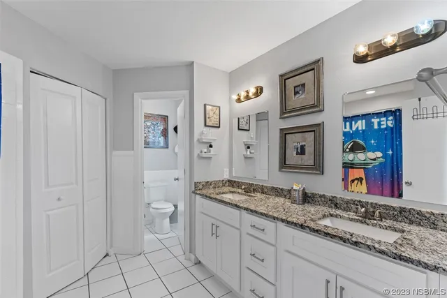 a spacious bathroom with a granite countertop sink and a mirror
