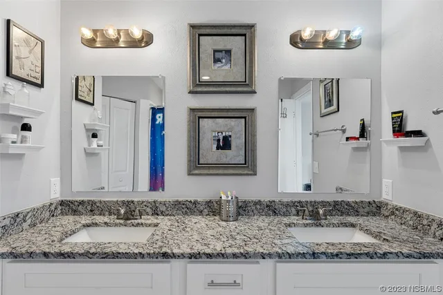 a bathroom with a granite countertop sink and a mirror