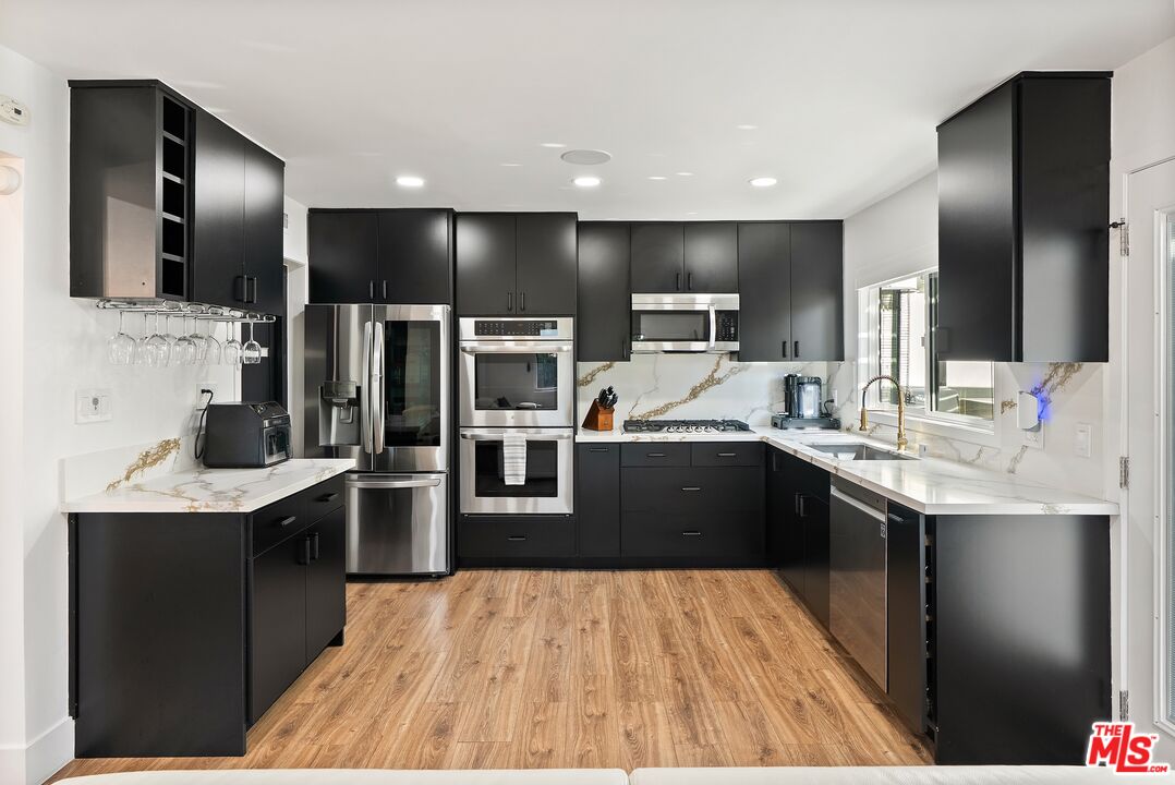 4118 Oak Hollow Road Calabasas, CA 91302 - Photo 20 of 55 a kitchen with stainless steel appliances kitchen island granite countertop a sink counter space and stainless steel appliances