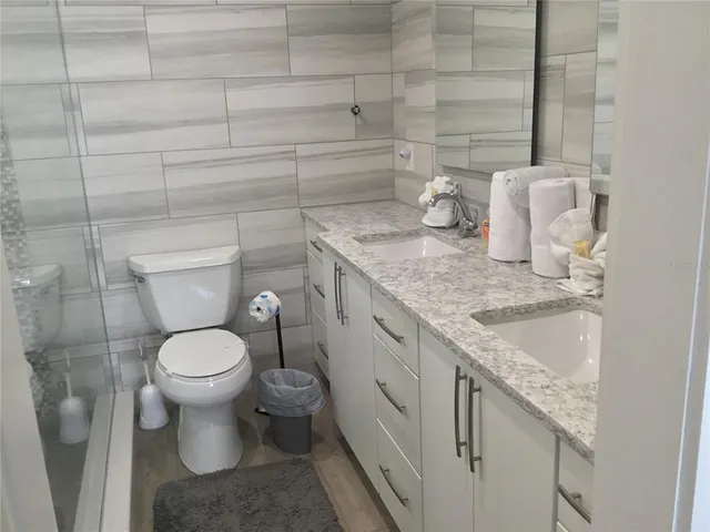 a bathroom with a granite countertop toilet and sink
