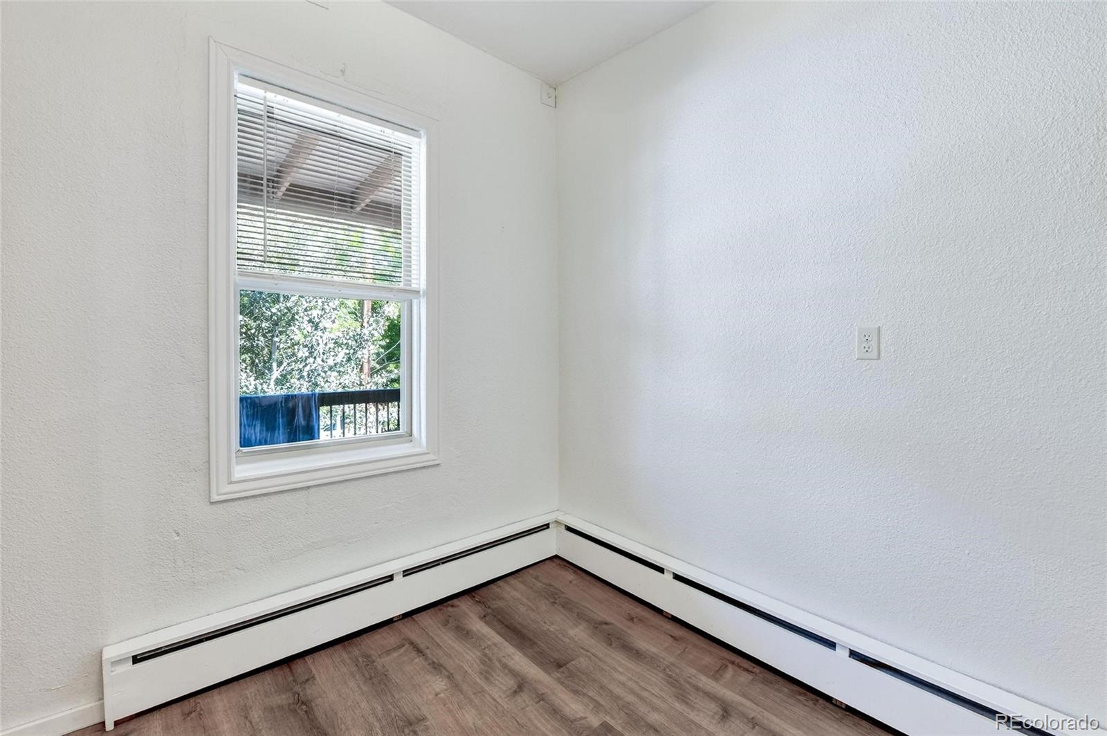 3127 West 28th Avenue, Unit 2 Denver, CO 80211 - Photo 12 of 30 a view of an empty room with wooden floor and a window